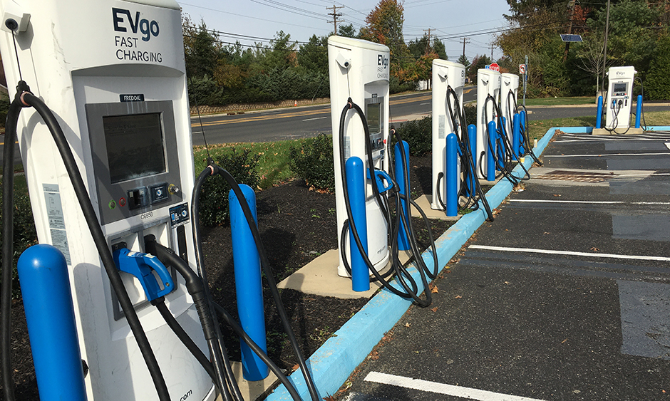 A row of electric vehicle chargers in a parking lot
