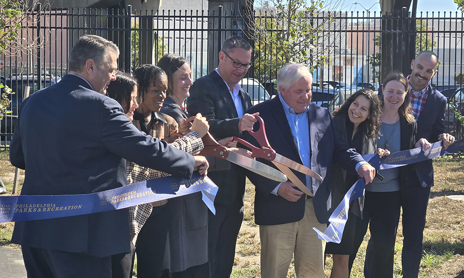 A group of people cutting a ribbon during a ceremony