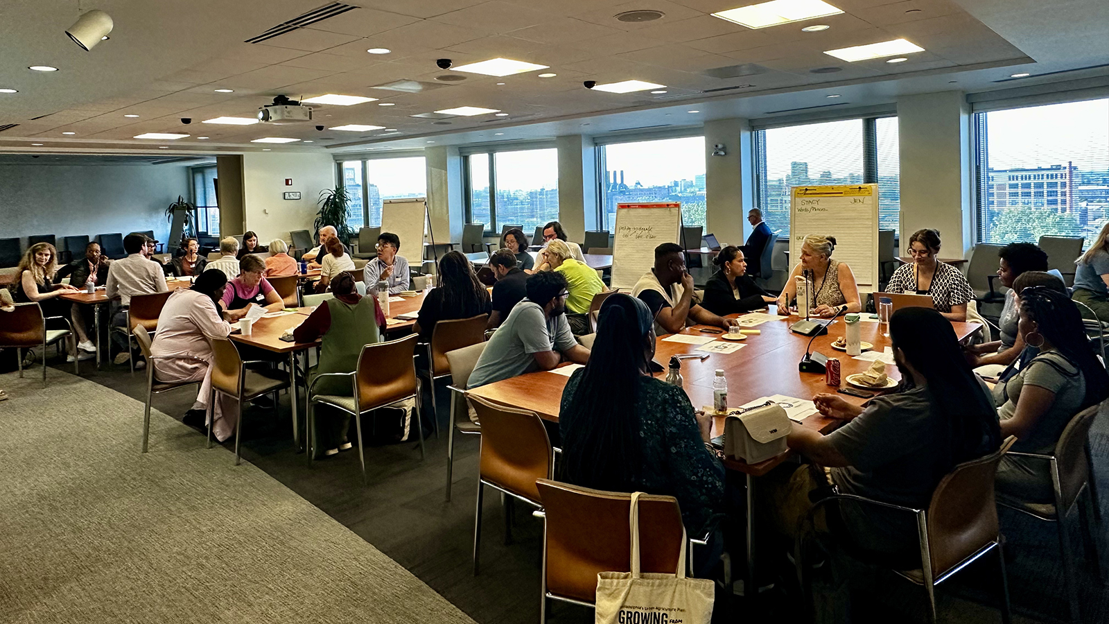 People sitting around tables in a conference room during a workshop