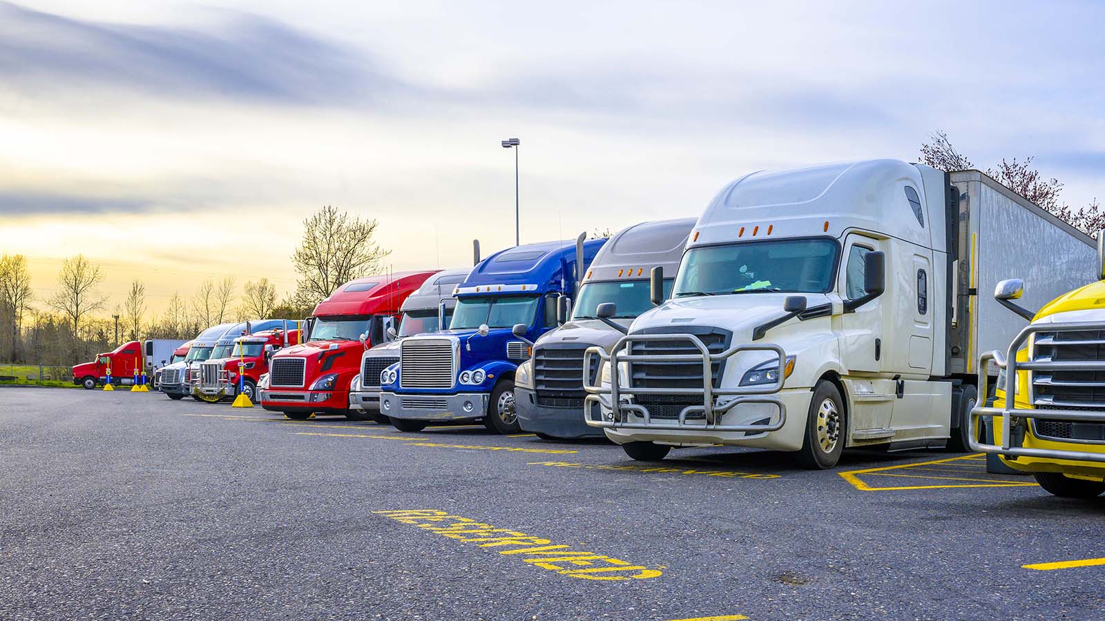 Big rig trucks parked in a row reserved for freight truck parking.