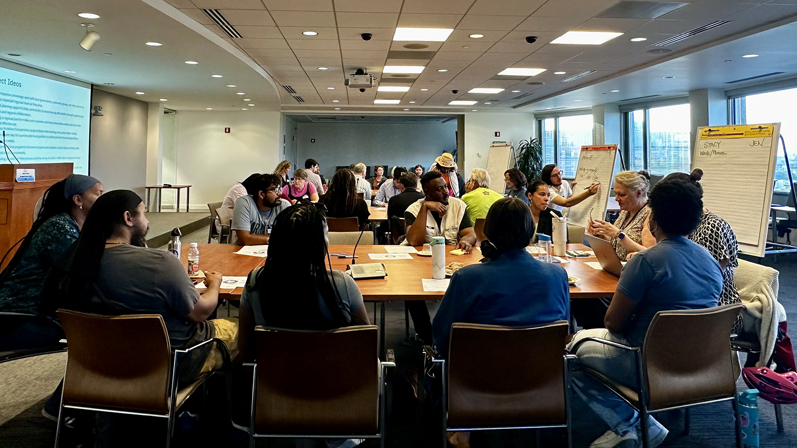 People sit around tables during a workshop in a conference room